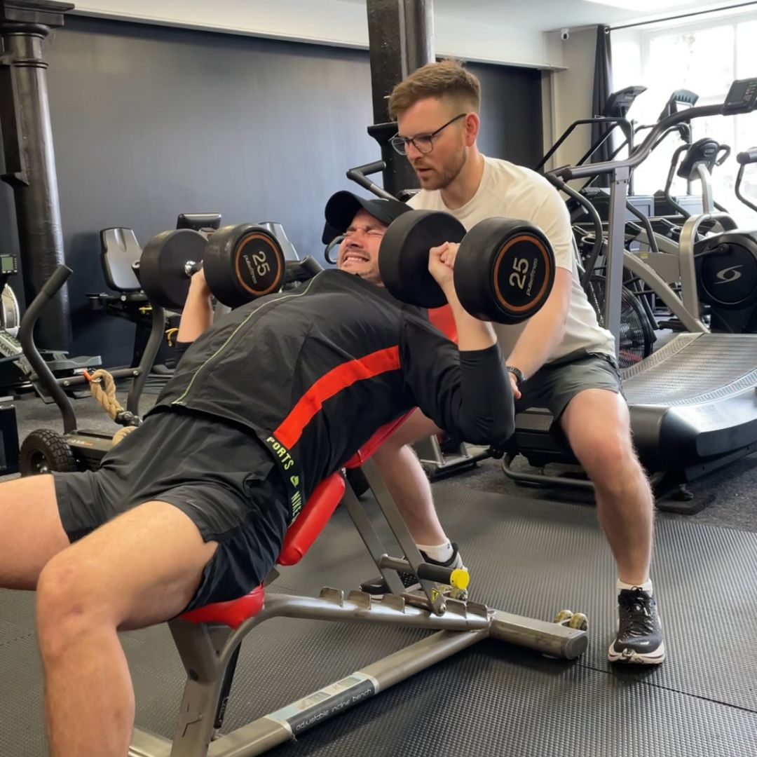 Calum Bryan coaching a client through an incline dumbbell press
